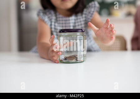 Ragazza per raggiungere il suo pocket money Foto Stock