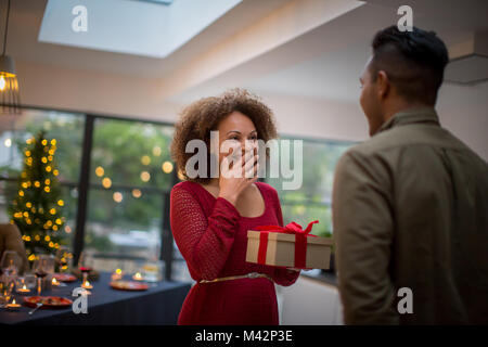 Donna essendo dato un regalo di Natale Foto Stock