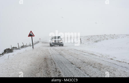 Hawes e Kettlewell, UK. 14 Febbraio, 2018. Condizioni di Blizzard sulla flotta Moss strada tra Hawes e Kettlewell, la più alta strada nello Yorkshire, come l'inverno bite continua. Credito: Wayne HUTCHINSON/Alamy Live News Foto Stock