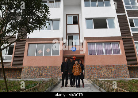 Chengdu. 3 febbraio, 2018. Cai Jiwen (1L) e la sua famiglia posano per una foto di gruppo di fronte la loro nuova casa in villaggio Jiuyin Yuehua di città in città Dazhou nel sud-ovest della Cina di provincia di Sichuan, Febbraio 3, 2018. Il 46-anno-vecchio lavoratore migrante Cai e da sua moglie torna a casa in treno nel febbraio 1. La loro nuova casa, uno dei 144 appartamenti costruiti per i residenti trasferiti dalle aree povere, si trova in un insediamento nel villaggio Jiuyin Yuehua di città in città Dazhou nel sud-ovest della Cina di provincia di Sichuan. Credito: Liu Kun/Xinhua/Alamy Live News Foto Stock