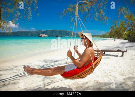 Un uomo su una spiaggia tropicale a Koh Rong Samloem isola in Cambogia. Foto Stock