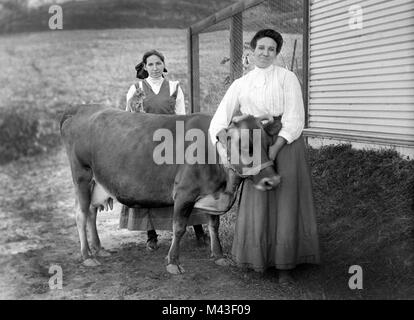Madre e figlia, mucca, e cat posare per un ritratto, ca. 1915. Foto Stock