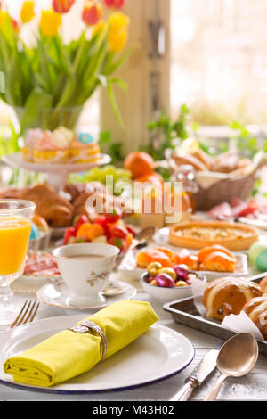 La colazione o il brunch tabella riempita con tutti i tipi di deliziosa gastronomia pronta per un pasto di Pasqua. Foto Stock