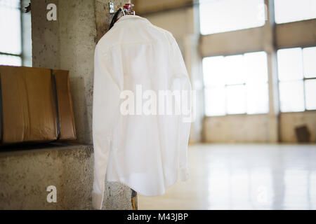 Immagine della camicia bianca appesa in magazzino Foto Stock