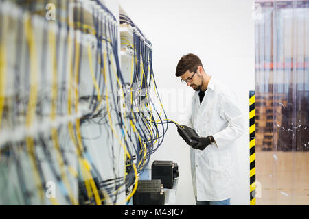 Immagine del tecnico di rete modem di collaudo in fabbrica Foto Stock