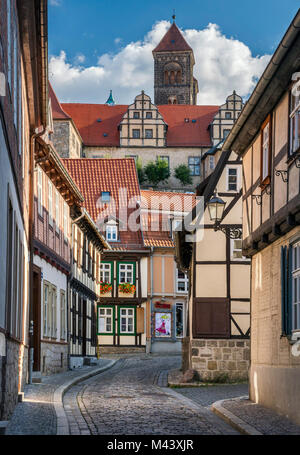 Semi-case con travi di legno vicino Schlossberg (Castle Hill), la torre di San Servazio chiesa Stiftskirche () sulla parte superiore, a Quedlinburg, Sassonia-Anhalt, Germania Foto Stock