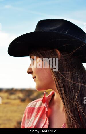 Ragazza in nero Cowgirl Hat guardando fuori nel deserto Foto Stock