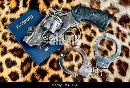 Vecchia pistola,le manette e il passaporto in pelle di leopardo. Foto Stock
