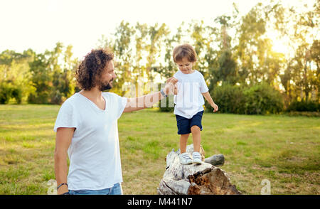 Padre giocando con suo figlio nel parco. Foto Stock