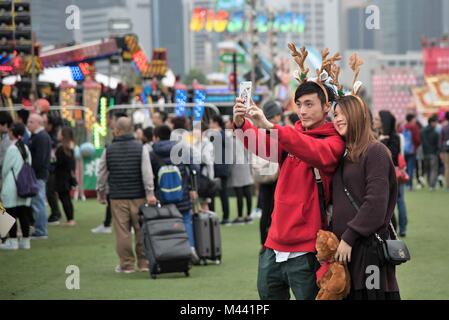 Un giovane prende un selfie all'AIA Carnevale europeo alla vigilia di Natale del 2016, mentre lo smartphone contiene anche un pic del giovane. Foto Stock