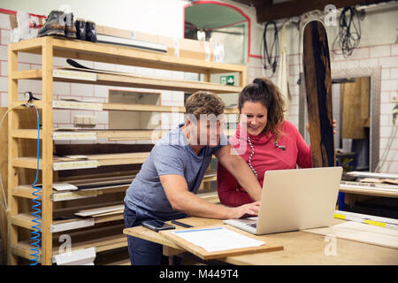 L uomo e la donna in officina, utilizzando laptop Foto Stock