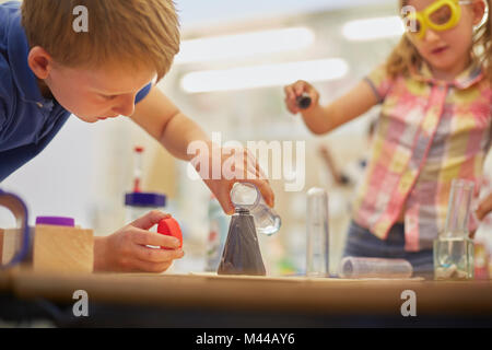 Scolaro primaria e una ragazza facendo provetta esperimento in aula Foto Stock