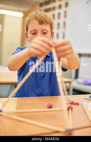 Scolaro rendendo la sfera e stick modello in aula presso la scuola primaria Foto Stock