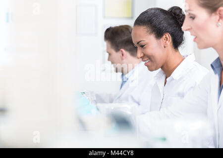 Un gruppo di ricercatori durante il lavoro sui dispositivi in laboratorio Foto Stock