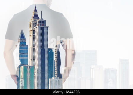 Doppia esposizione di imprenditore con le mani nelle tasche e di edifici per uffici Foto Stock