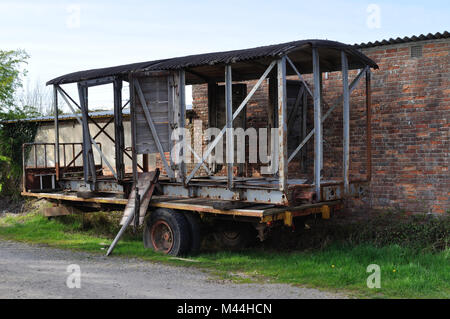Resti di un carro ferroviario su un rimorchio in una fattoria vicino a Wimborne, Dorset. L'originale tetto in legno sembra essere stato coperto da ferro corrugato. Foto Stock