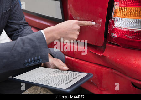 Agente di assicurazione della mano di assicurazione di riempimento secondo la rivendicazione formare sulla tavoletta digitale dopo l incidente di automobile Foto Stock