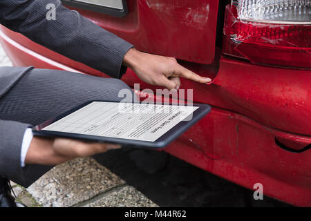 Agente di assicurazione della mano di assicurazione di riempimento secondo la rivendicazione formare sulla tavoletta digitale dopo l incidente di automobile Foto Stock