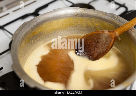 Fare marmellata fatta in casa con Saville arance di cottura in cui vi è un rischio elevato di zucchero mix di marmellata bollente sul fornello se dimentica di mantenere in agitazione Foto Stock