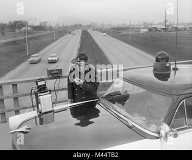Poliziotto utilizza la nuova tecnologia di radar per la cattura di speeders sul Edens Expressway in Chicago, ca. 1960. Foto Stock