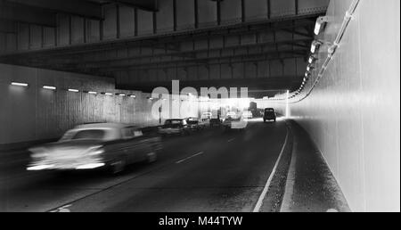 Il traffico si muove attraverso una recentemente costruita Hubbard's Cave sul Kennedy Expressway nel centro di Chicago, ca. 1963. Foto Stock