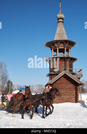NOVOSIBIRSK, Russia - 11 gennaio 2018: Troika di cavalli imbrigliato a una slitta. Folk slavo festività invernali Shrovetide. La Chiesa del Savio Foto Stock