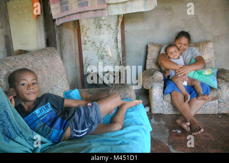 Una mamma e i suoi 2 figli piccoli a casa, Rakiraki, Fiji. Foto Stock