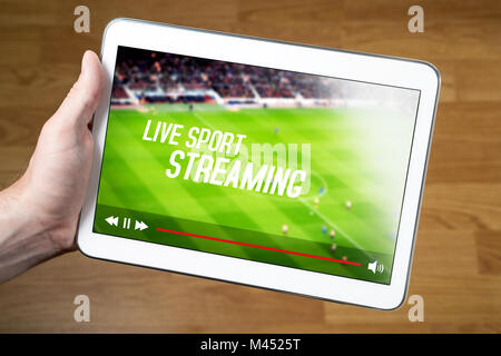 L'uomo guarda sport live stream online con il dispositivo mobile. Mano azienda tablet con immaginario lettore video e il servizio di streaming. Foto Stock