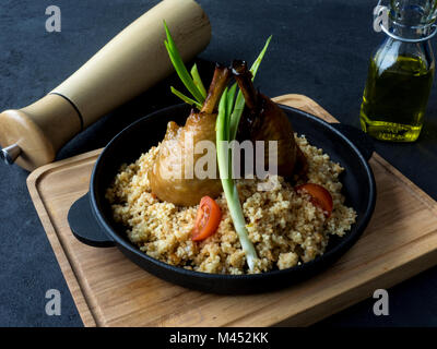 Pollo alla griglia gambe con couscous in una ghisa padella Foto Stock