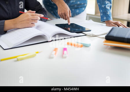 I giovani studenti del campus amico aiuta a recuperare e tutoraggio di apprendimento. Persone, di apprendimento, di istruzione e di concetto di scuola. Foto Stock