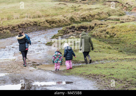 Le madri e i loro figli a camminare su una pista melmosa a Ruvida Tor su Bodmin Moor in Cornovaglia. Foto Stock