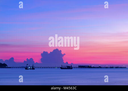 Il sole tramonta dietro un piccolo molo , Sunset beach Foto Stock