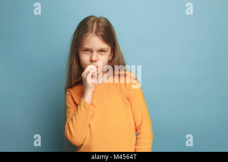 La premurosa ragazza. Teen girl su uno sfondo blu. Le espressioni del viso e persone emozioni concetto Foto Stock