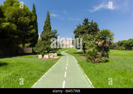 Una pista ciclabile accanto alle mura antiche della città di Cartagena, Spagna. Foto Stock