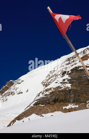 Il superiore sud pendici del Mönch, dal ghiacciaio Jungfraufirn, Svizzera, con un vestito di stracci Swiss bandiera nazionale in primo piano Foto Stock