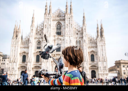 Alimentazione ragazzo piccioni in Milano Piazza del Duomo di Milano, Lombardia, Italia Foto Stock