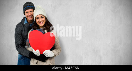 Immagine composita di festosa giovane in abbigliamento invernale Foto Stock