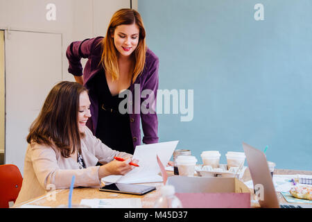 I colleghi in ufficio a discutere di documenti cartacei Foto Stock