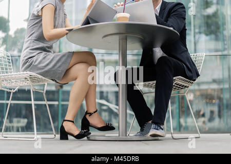Giovane imprenditrice e uomo incontro al cafè sul marciapiede, il collo verso il basso consente di visualizzare Foto Stock