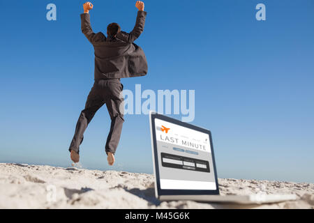 Immagine composita di imprenditore vittorioso jumping lasciando il suo computer portatile Foto Stock