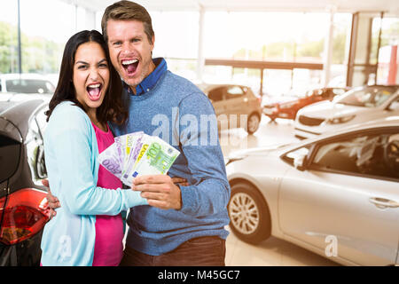 Immagine composita di eccitato giovane azienda denaro Foto Stock