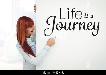 Immagine composita di sorridere hipster donna dietro una carta bianca Foto Stock