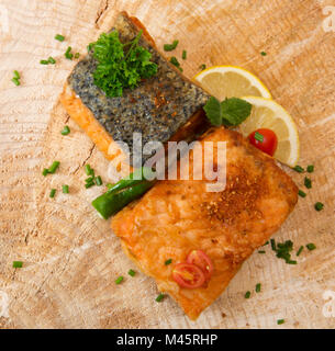 Bistecca di salmone con limone su sfondo di legno. Foto Stock