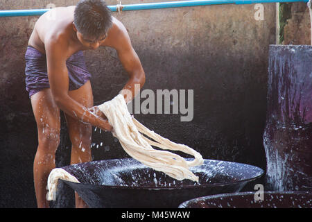 Uomini al lavoro e stomping nel lavaggio di cassonetti nella fabbrica di tessuto in Myanmar Mandalay Foto Stock