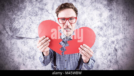 Immagine composita di geeky hipster tenendo un cuore spezzato Foto Stock