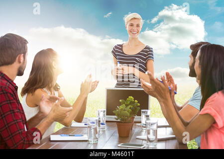 Immagine composita di colleghi battendo le mani in una riunione Foto Stock