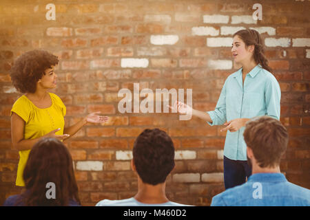 Immagine composita di casual giovane imprenditrice dando la presentazione ai colleghi Foto Stock
