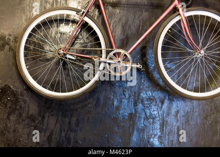 Sfondo, lifestyle, in stile rustico concetto. vi è vintage bicicletta sul nero a superficie ruvida, è pulire le ruote e i pedali, fresche telaio verniciato Foto Stock