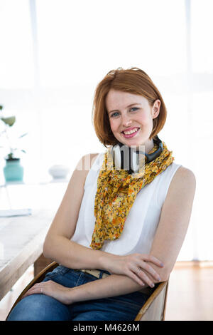 Sorridente hipster business donna seduta alla sua scrivania Foto Stock