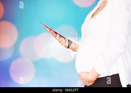 Immagine composita della sezione mediana della donna incinta con tavoletta digitale Foto Stock